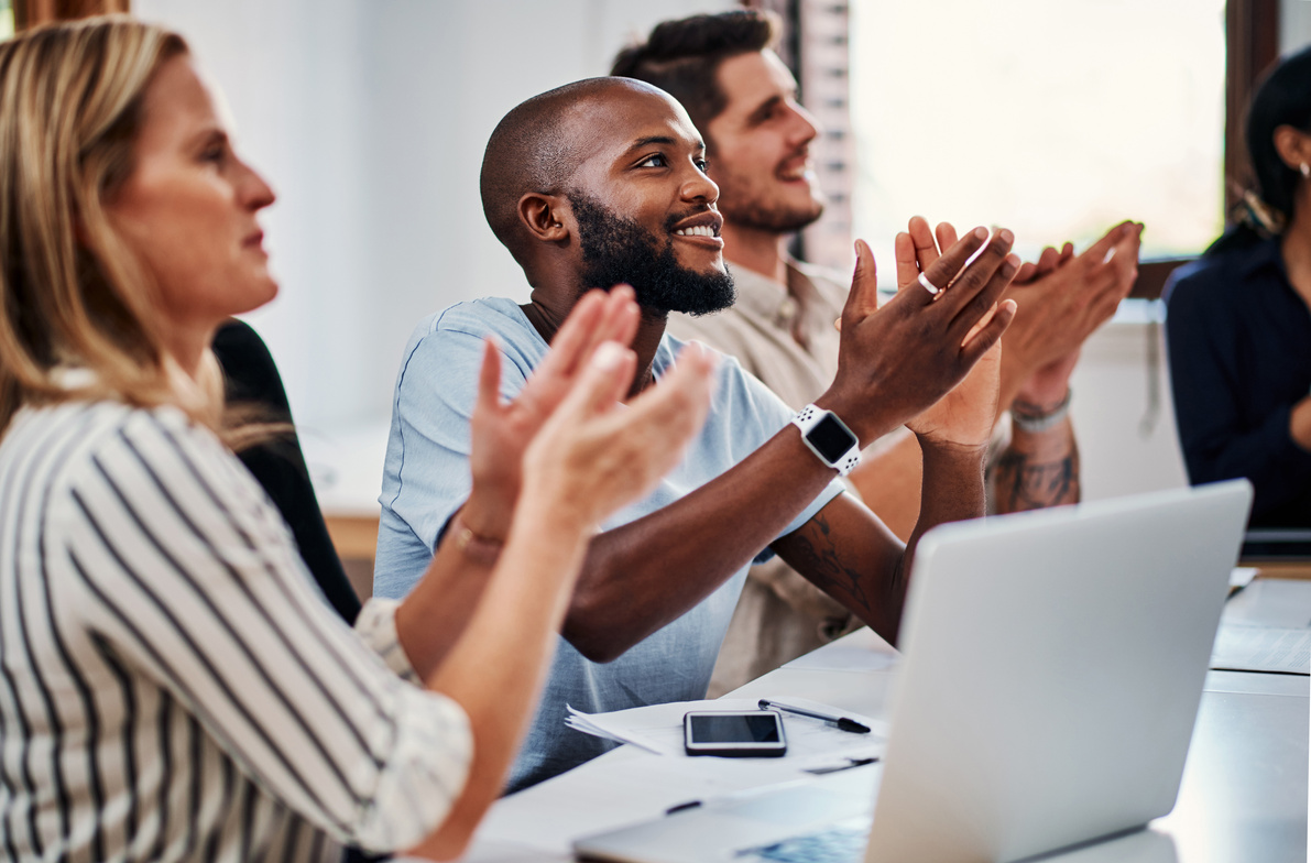 a group of people clapping at a meeting